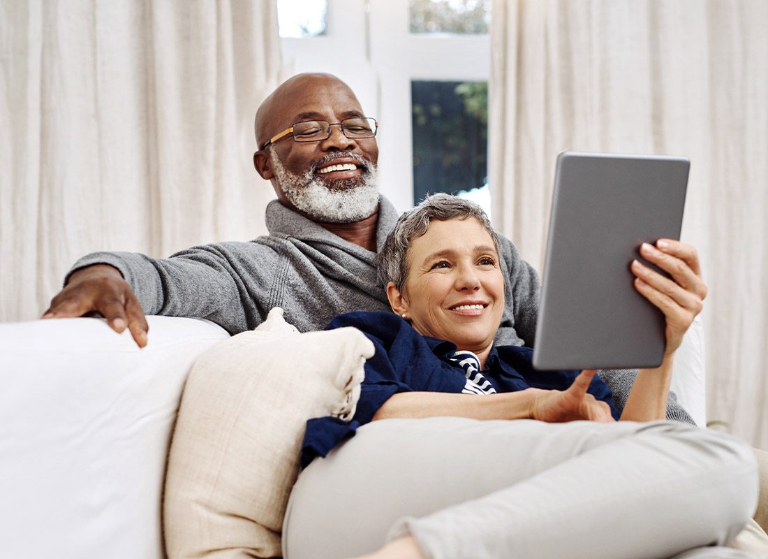 Resources - Senior Couple Looking at a Tablet While Sitting on the Sofa